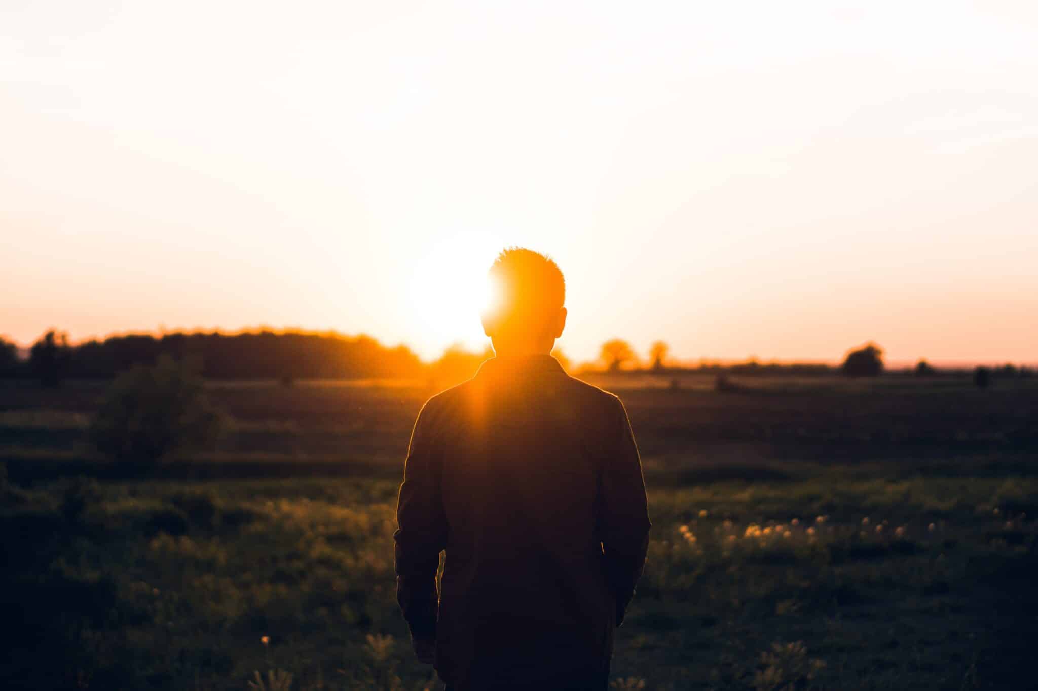 Man looking at the sunset | Photo by Warren on Unsplash