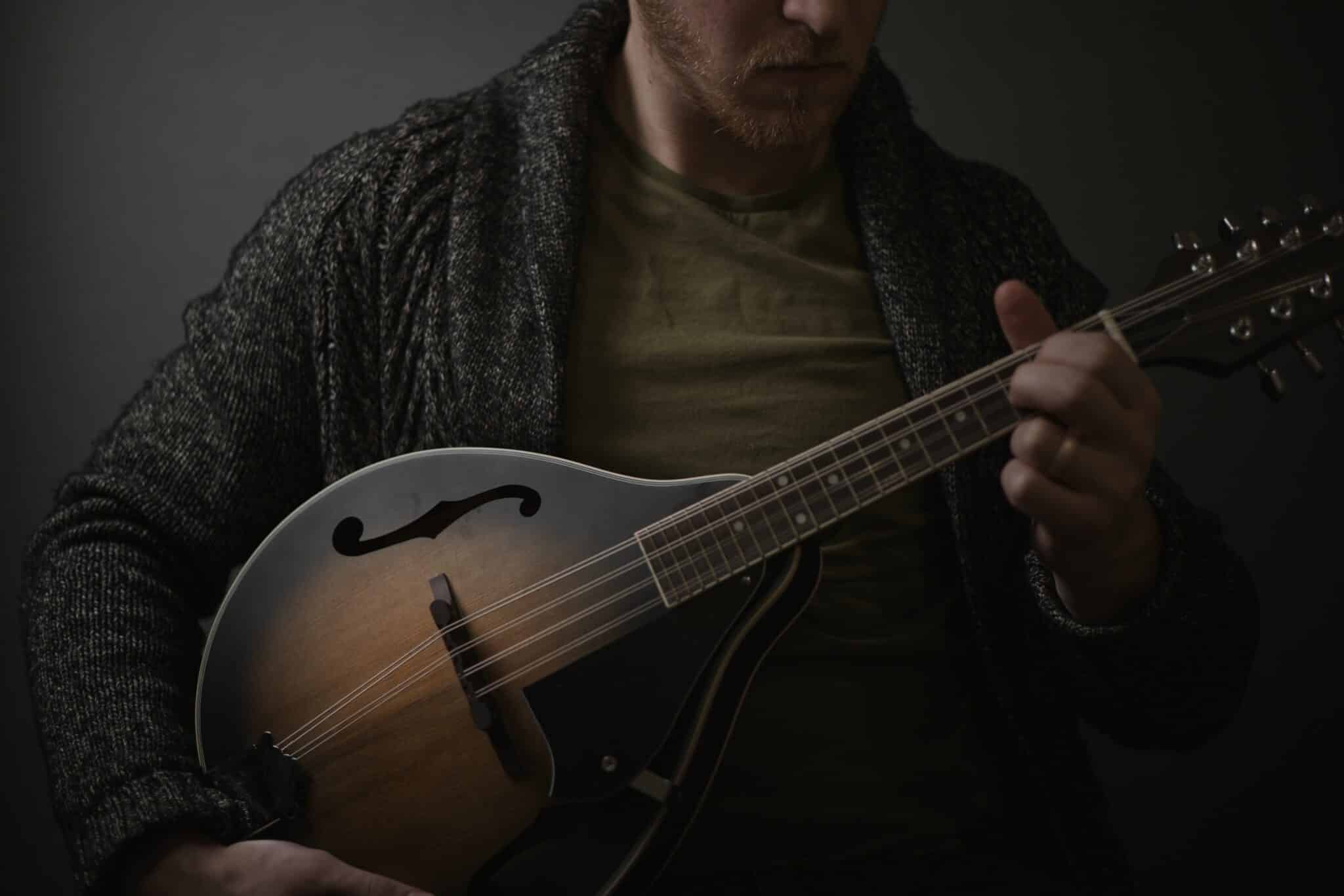 man playing a lute | Photo by Luke Peterson on Unsplash