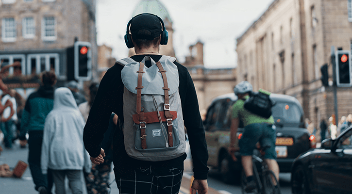 young man listening to music on busy street