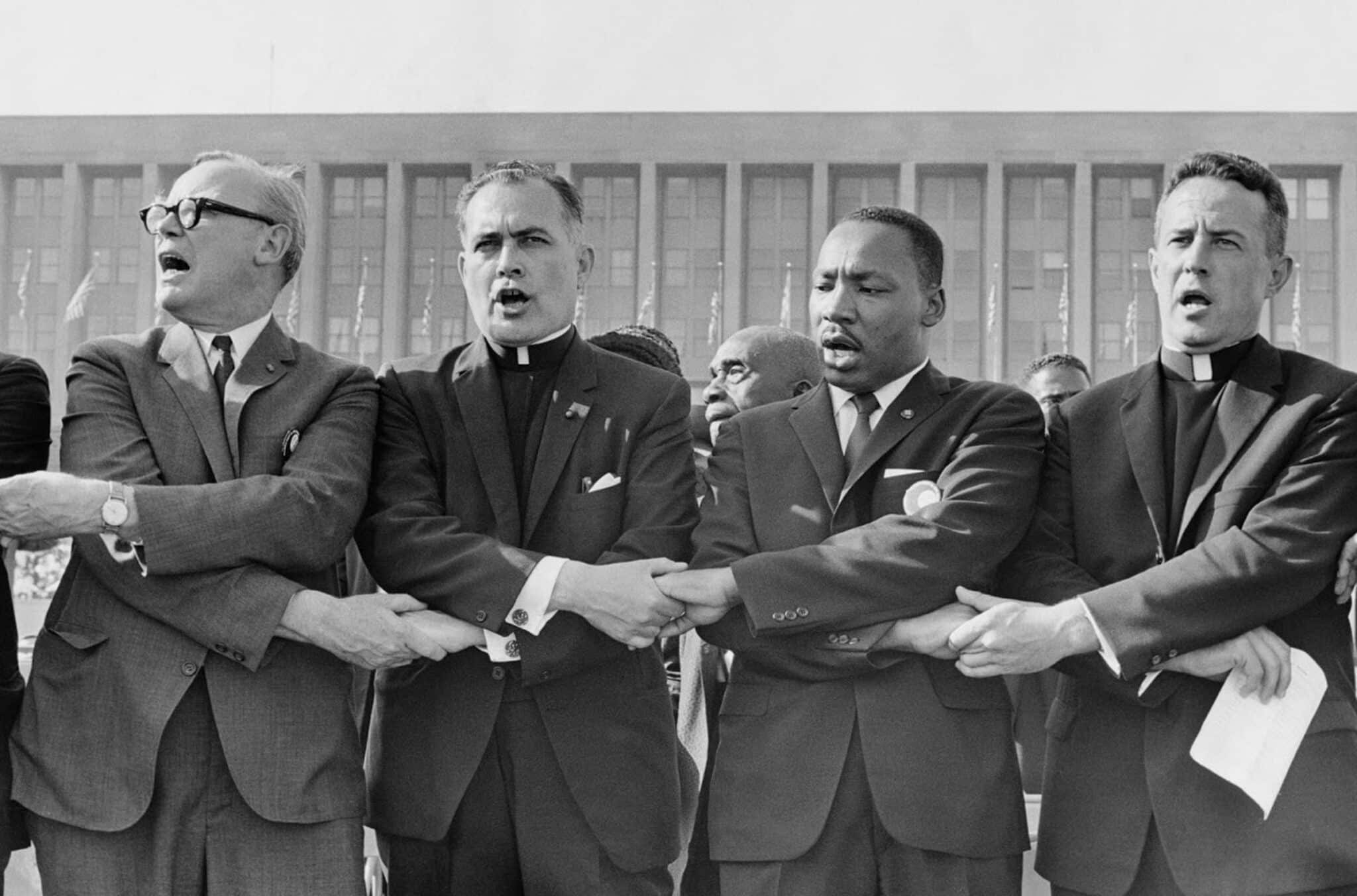 Holy Cross Father Theodore Hesburgh, then president of the University of Notre Dame, second from left, joins hands with the Rev. Dr. Martin Luther King Jr., the Rev. Edgar Chandler and Msgr. Robert J. Hagarty of Chicago, far right, in this 1964 file photo. As Rev. King taught, "we must confront the evils of racism and prejudice with the love of Christ," Archbishop Timothy P. Broglio of the U.S. Archdiocese for the Military Services, who is president of the U.S. Conference of Catholic Bishops, said in a Jan. 10, 2024, statement ahead of Martin Luther King Jr. Day Jan. 15. (OSV News photo/courtesy University of Notre Dame)