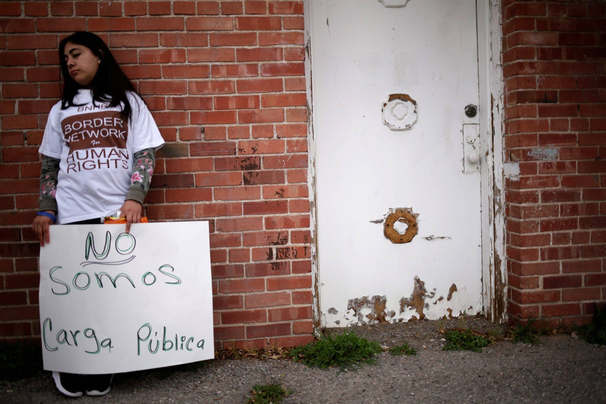 An young activist takes part in a vigil against alleged abuses by the U.S. Border Patrol outside of the Annunciation House migrant shelter in El Paso, Texas, Feb. 22, 2020. She holds a sign in Spanish that translates into English as "We are not a public charge." (OSV News photo/Jose Luis Gonzalez, Reuters)