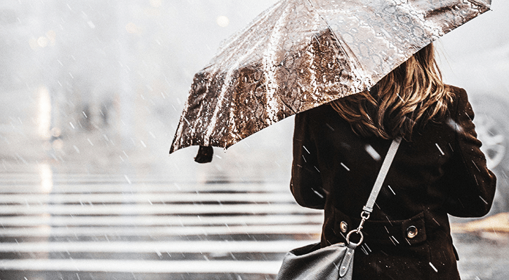 woman holding umbrella in storm