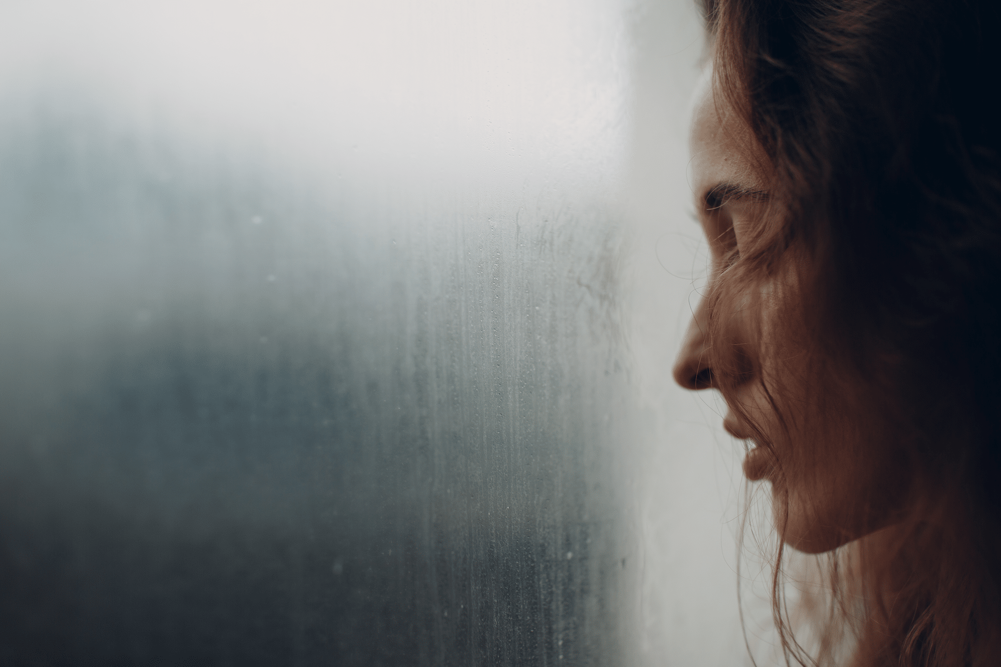 sad woman by rainy window