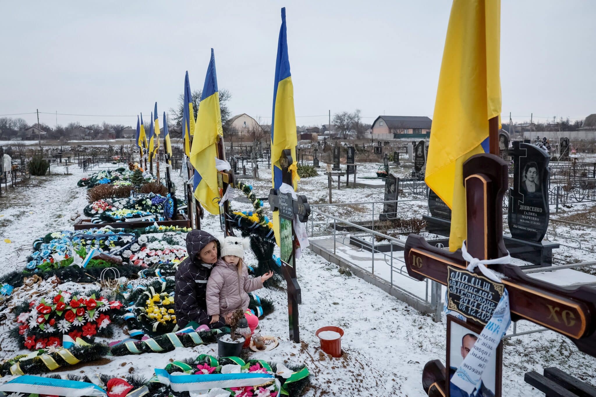 Alona Onyshchuk, 39, visits her husband's grave with her daughter, Anhelina, 5, at the Alley of Heroes at a local cemetery in the village of Lozuvatka, Dnipropetrovsk region, Ukraine, Jan. 22, 2024, amid Russia's attack on Ukraine. (OSV News photo/Alina Smutko, Reuters)