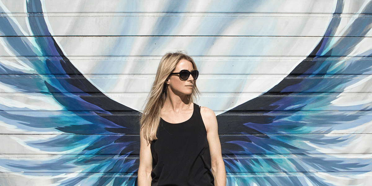 woman standing in front of painted wings