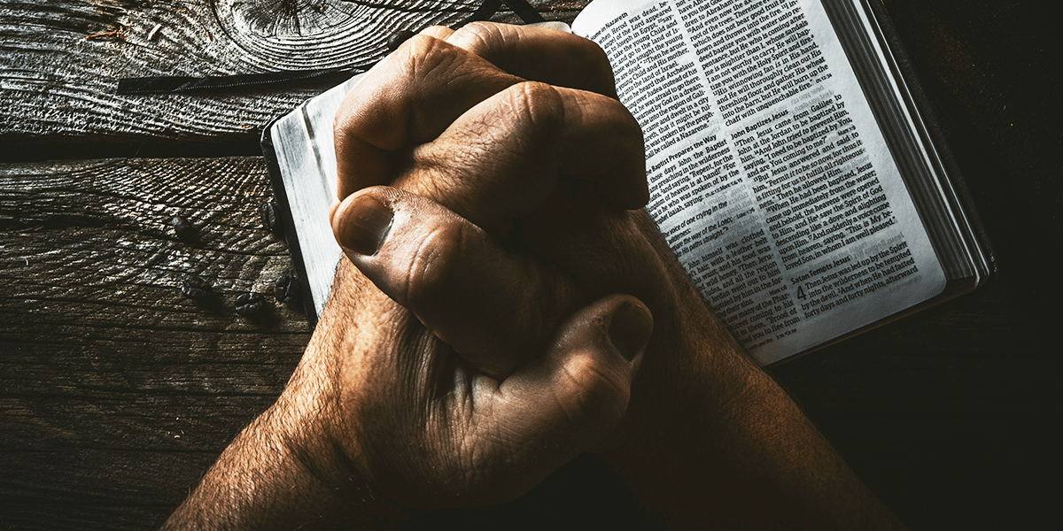 hands praying and person reading Bible