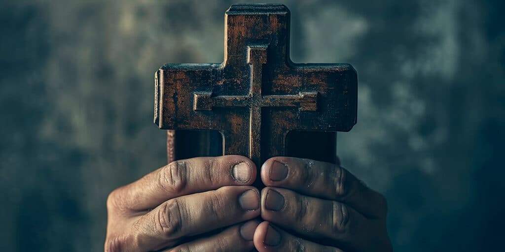 hands holding a cross