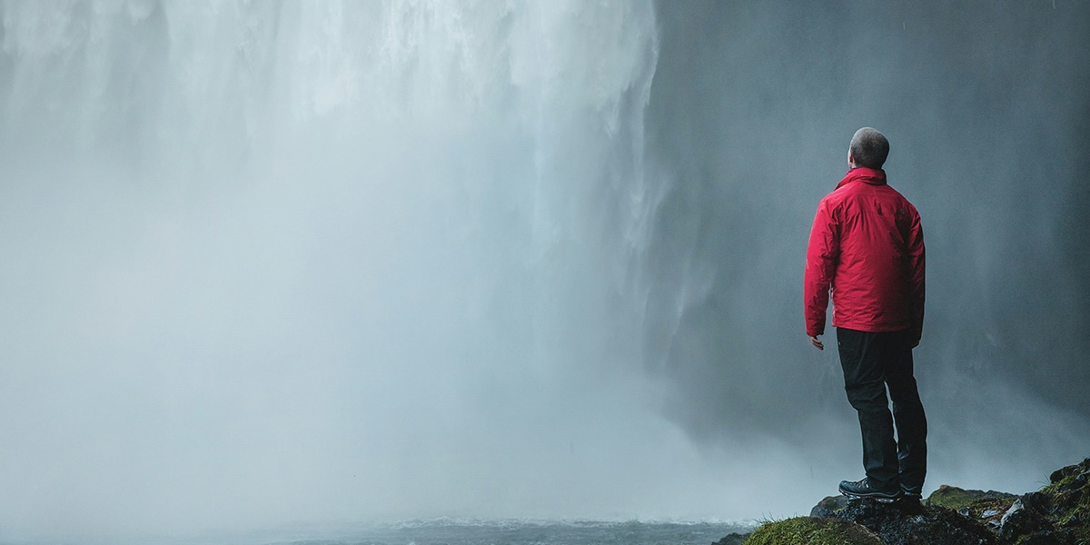 person standing by waterfall