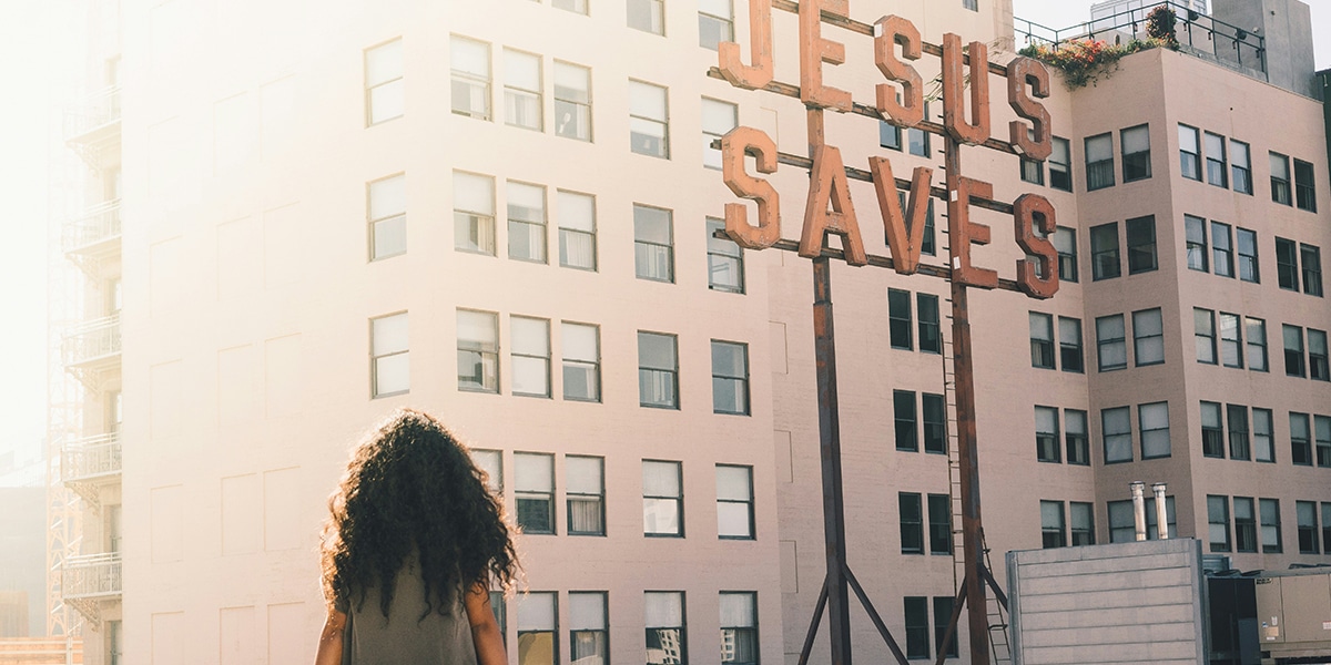 Woman looking at Jesus Saves sign