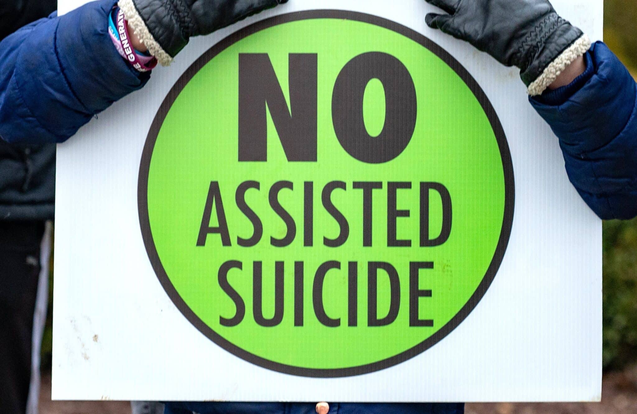 A person is pictured in a file photo holding a sign against physician-assisted suicide. (OSV News photo/Kevin J. Parks, Catholic Review)