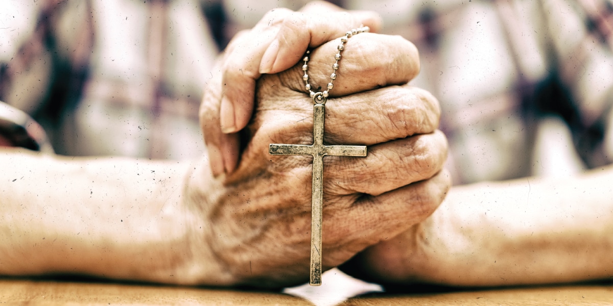 Woman holding a cross in prayer