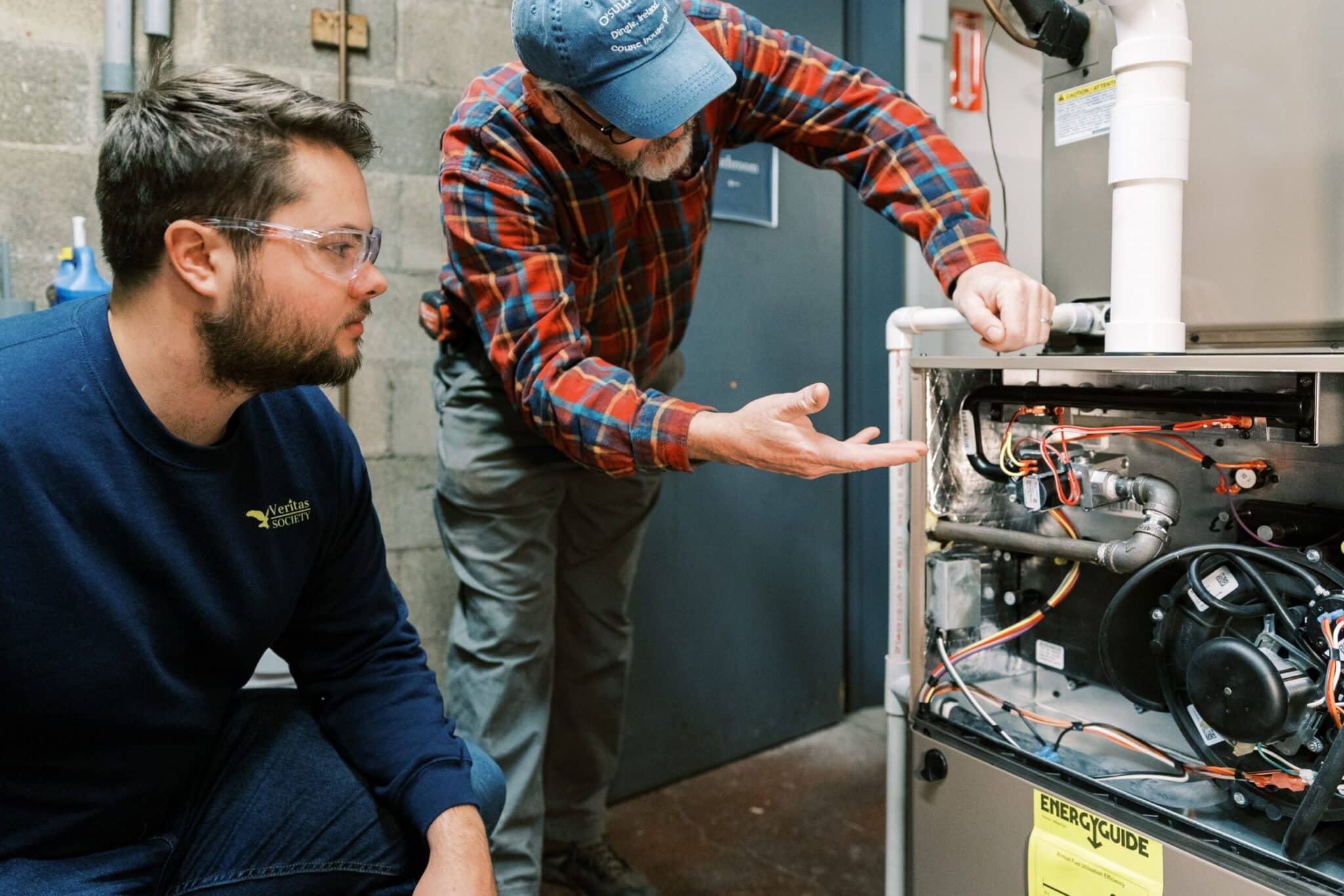 Mike Sullivan, president of the College of St. Joseph the Worker in Steubenville, Ohio, is pictured in an undated photo explaining the components of a standard furnace to a student. New Catholic schools across the U.S are part of a growing trend for career-focused education in fields such as construction, carpentry, and HVAC, while integrating spiritual growth into vocational training. (OSV News photo/courtesy College of St. Joseph the Worker)