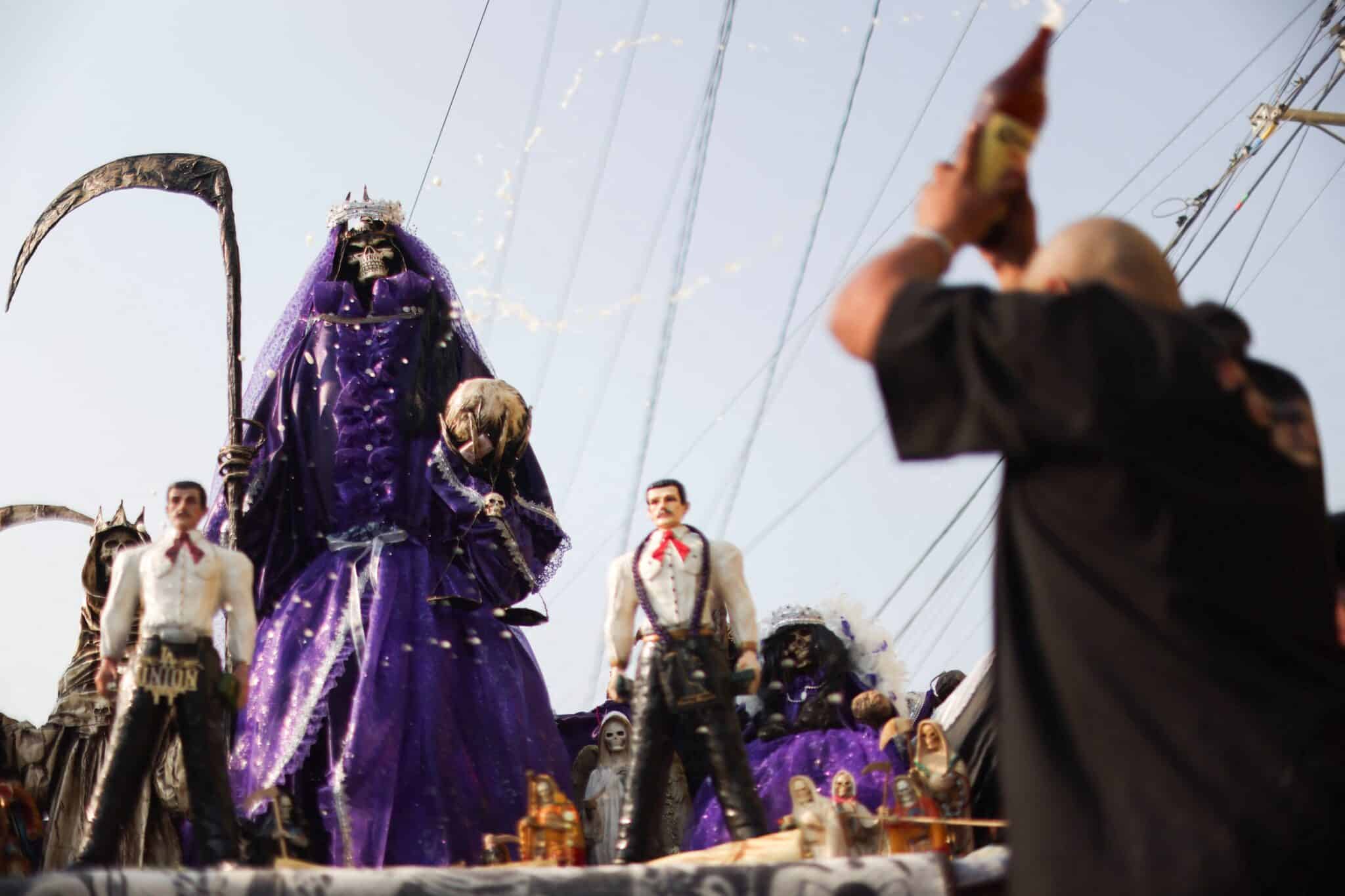 Jorge Granados, aka El Spanky, blesses Cristal, his image of La Santa Muerte, with beer Jan. 1, 2024, as he prepares for an annual pilgrimage from Ecatepec, Mexico, to the shrine of La Santa Muerte in Mexico City's Tepito neighborhood. Mexico's bishops criticized the use of an image of Santa Muerte, or St. Death, in political advertising during the presidential campaigns. (OSV News photo/Gustavo Graf, Reuters)