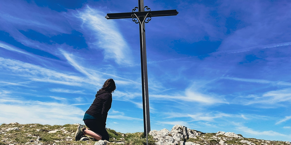 woman starring at an empty cross