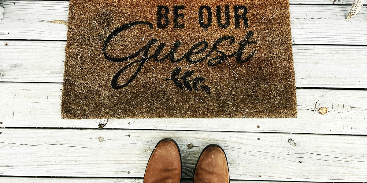 floor mat with the words "be our guest" and a pair of shoes