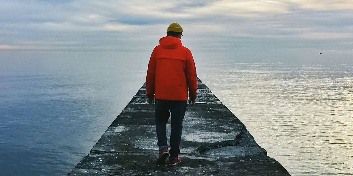 man walking down a pier