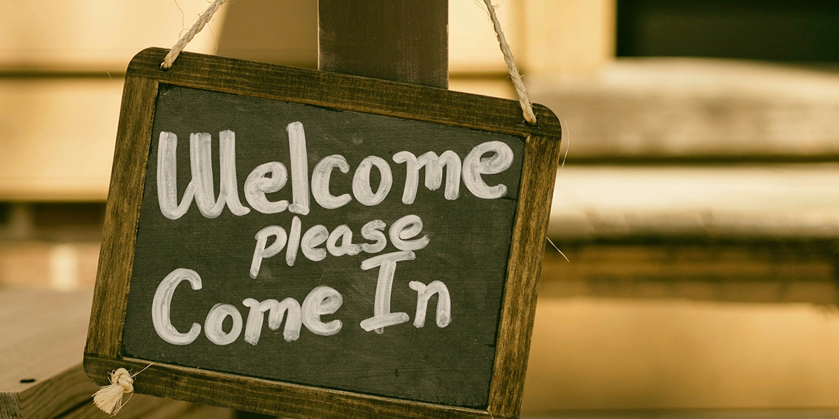 Chalkboard sign with "Welcome please come in" written on it
