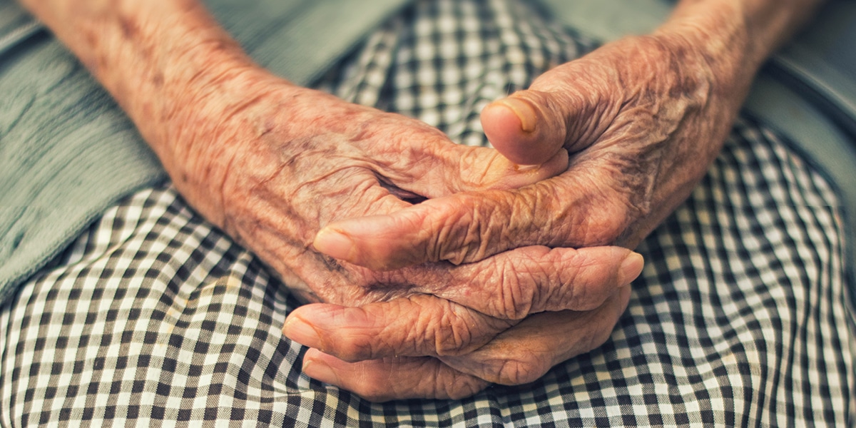 weak hands of an old person, folded in lap