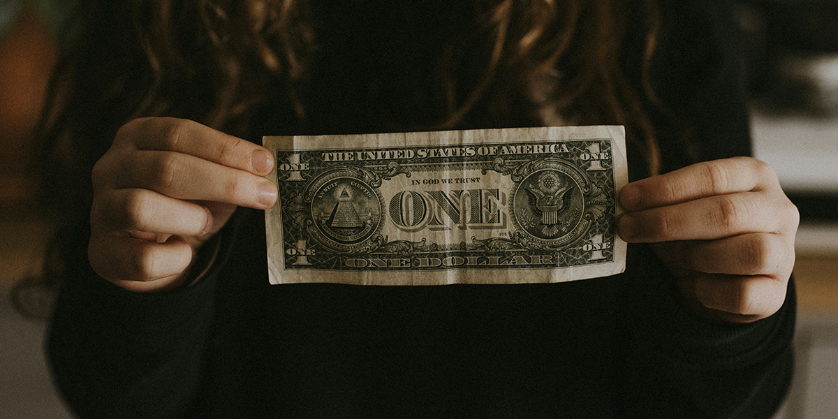 woman holding a one dollar bill in her hands.