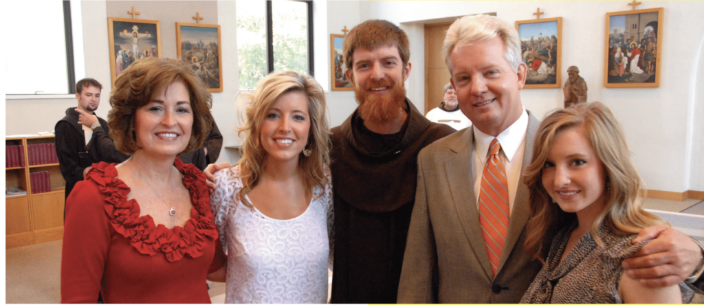 Group of people posing for picture with a Friar