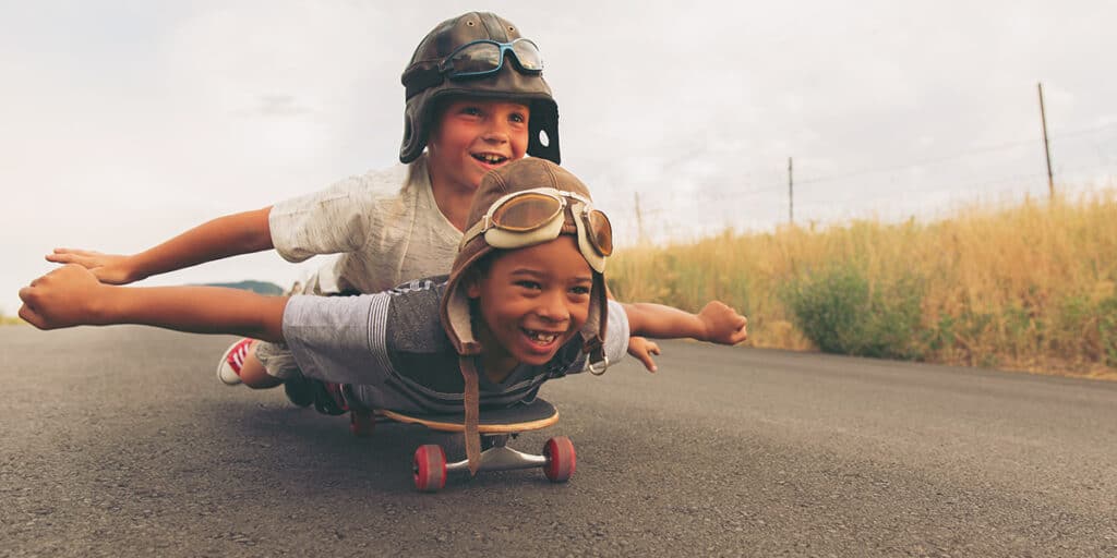 Two boys cruising fearless on a skateboard
