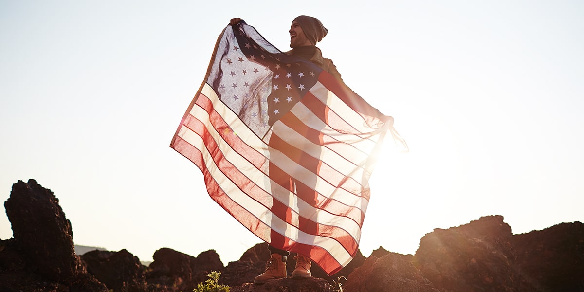 man holding American flag, transparent by sunlight