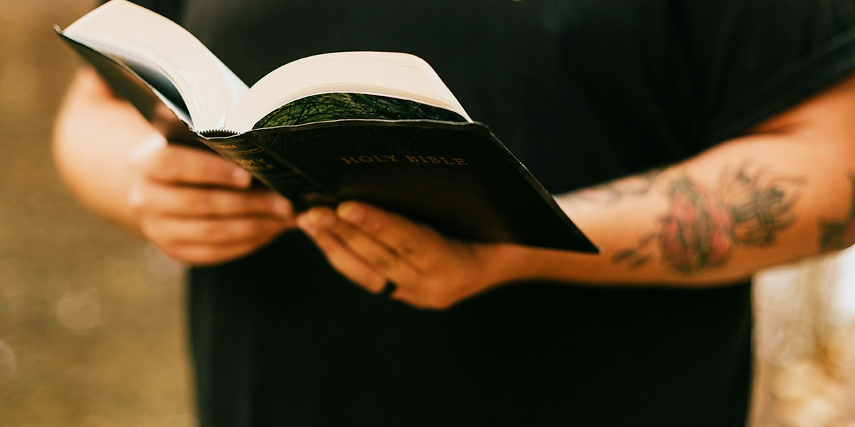 Man holding a bible while reading