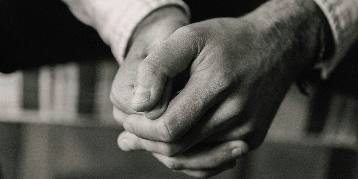 man praying with folded hands peacefully