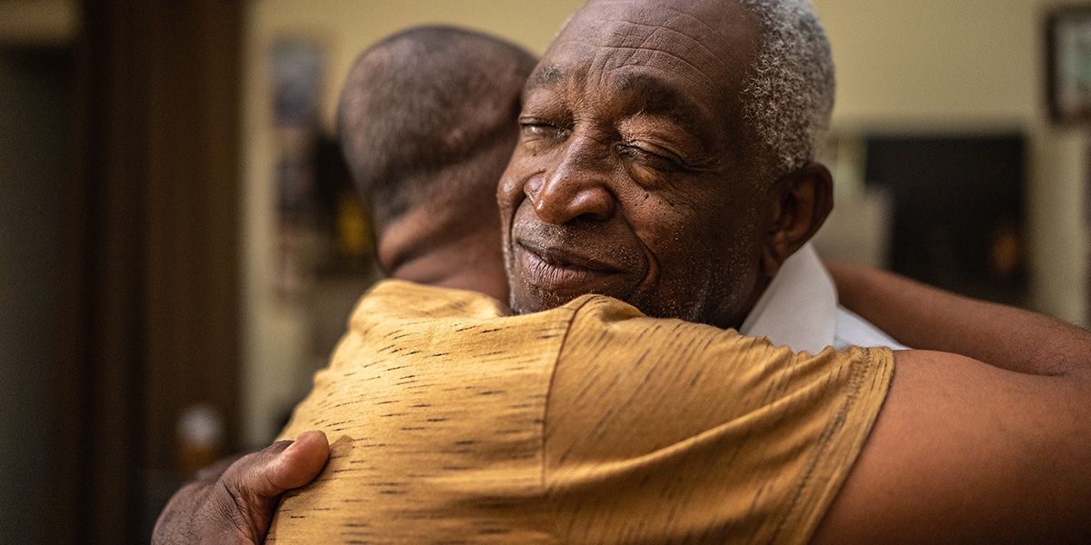 two men hugging, encouraging each other.