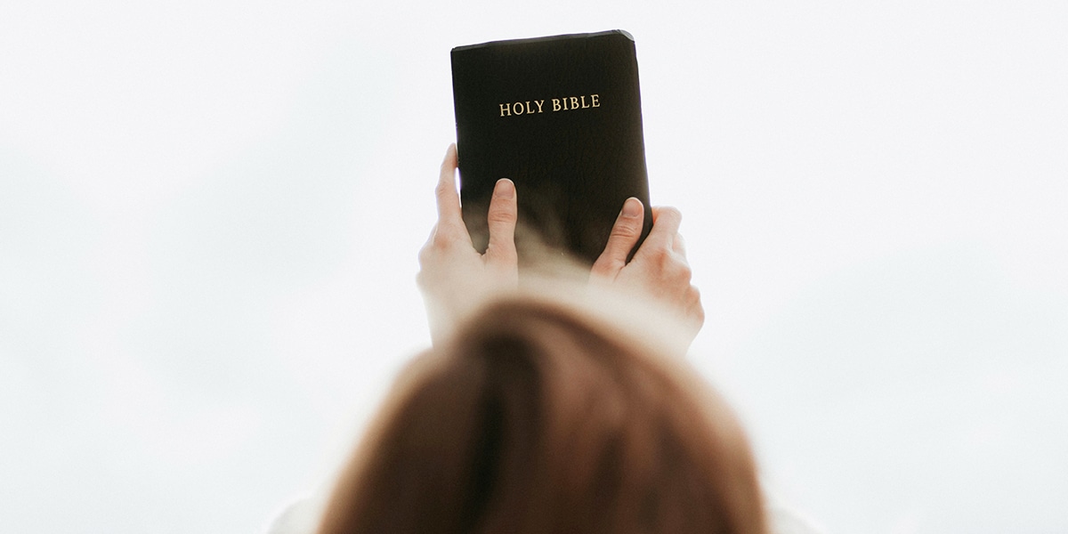 woman holding up a bible