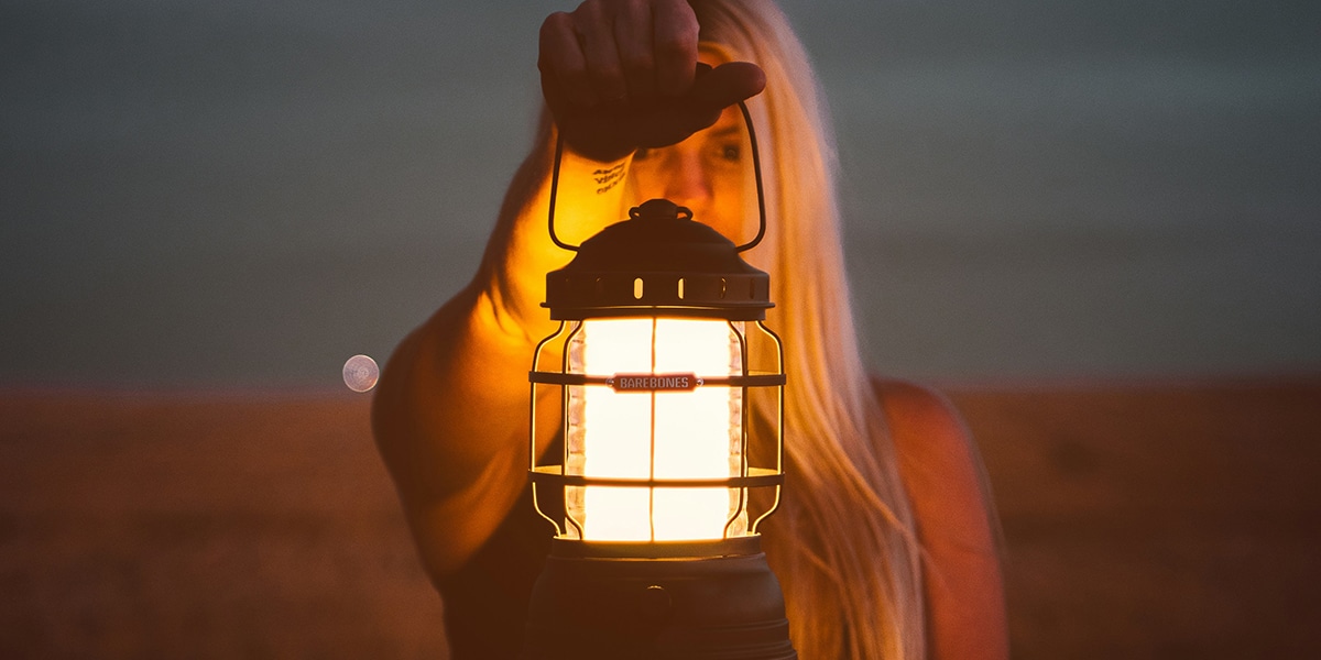 woman holding a lantern in the darkness