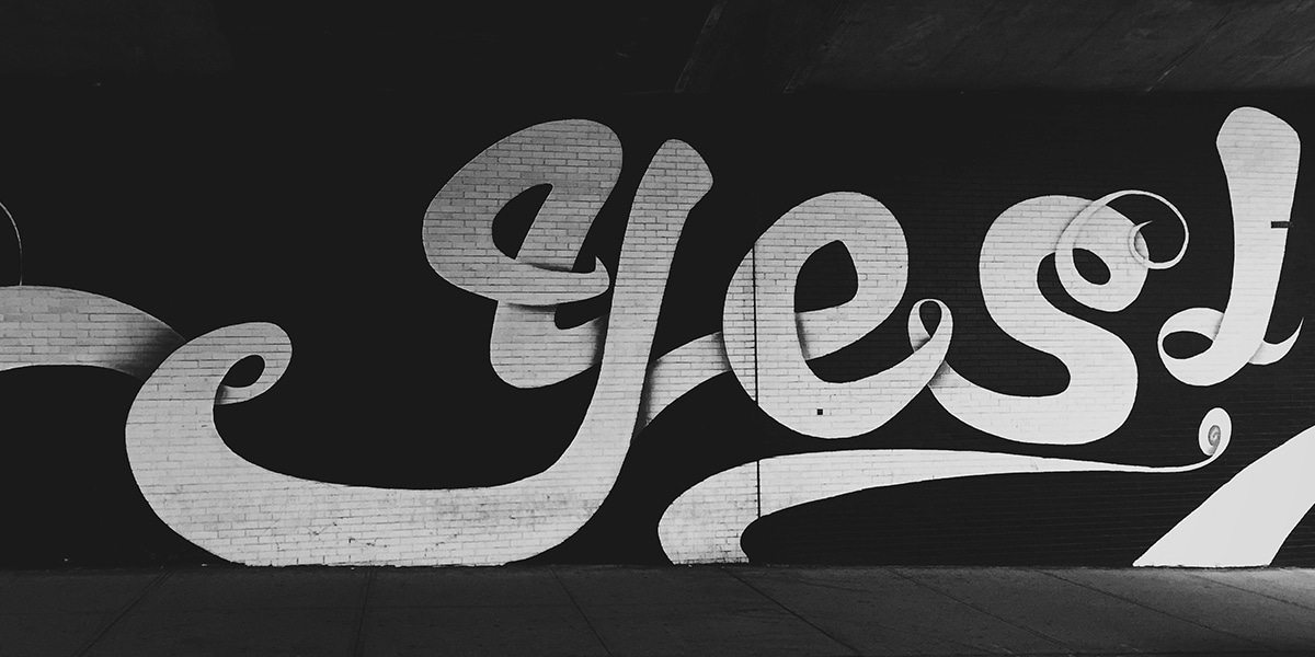 the word yes sprayed graffiti on a wall