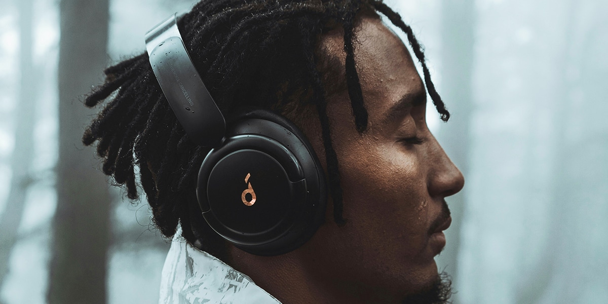 A young man wearing headphones, listening to music while relaxing