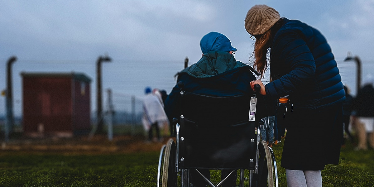 woman helping someone in a wheelchair.