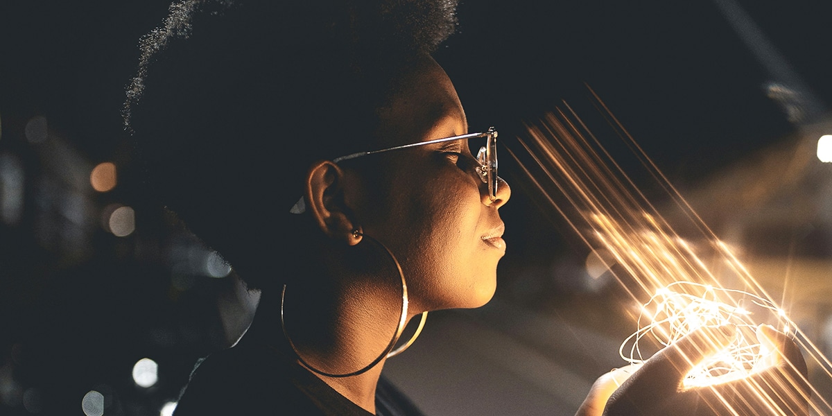 Woman holding bright lights in her hand
