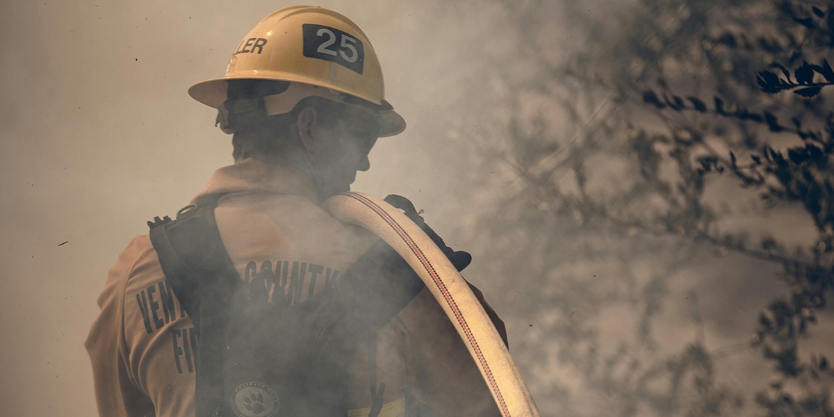Fireman walking through smoke and brush