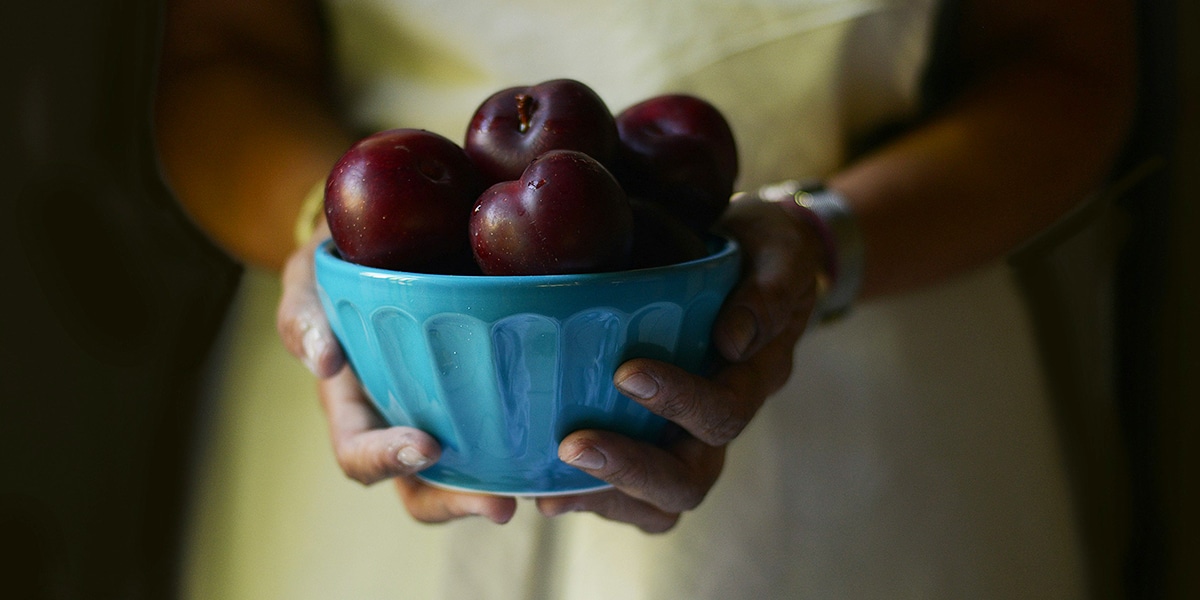 woman giving a bowl of apples to someone