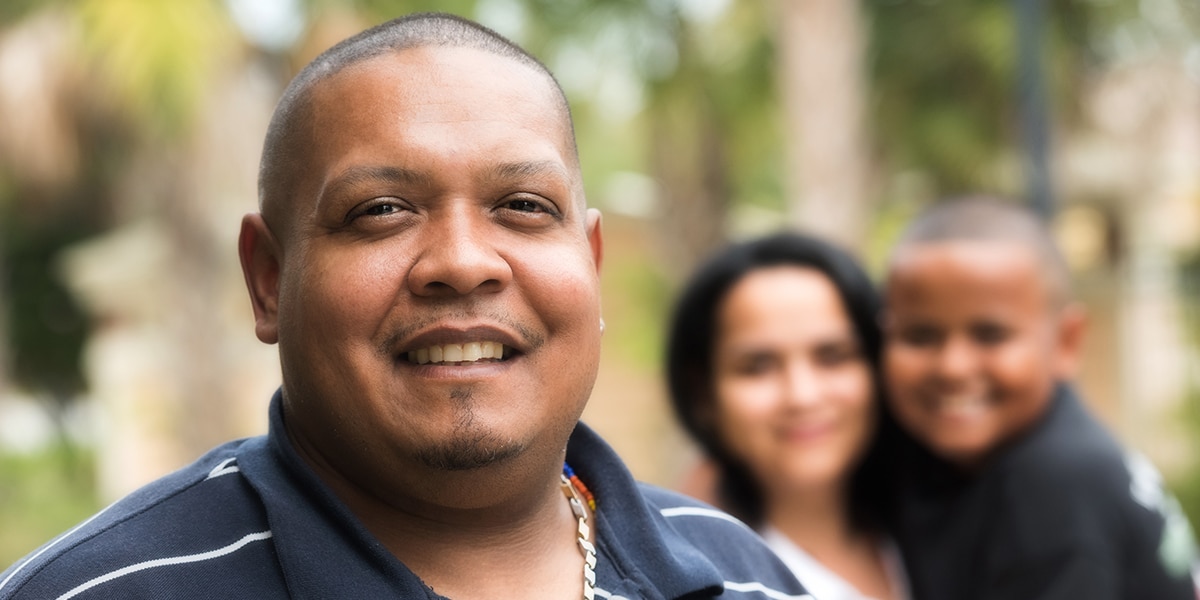 A immigrant with his family in the background