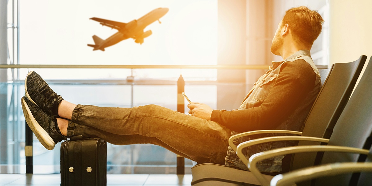 man waiting at an airport for his flight