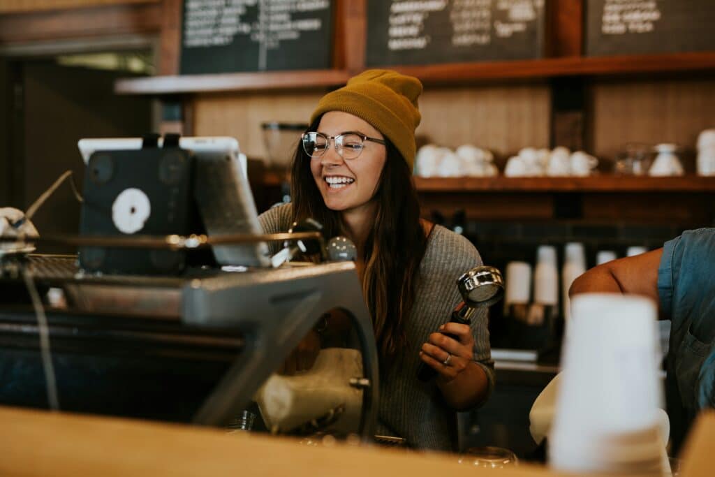 In this Labor Day photo, a woman works at a coffee shop | Photo by Brooke Cagle on Unsplash

