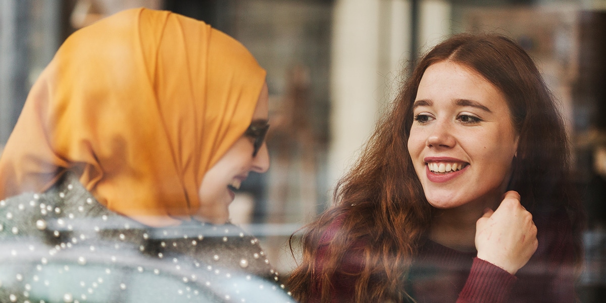 two young diverse woman talking