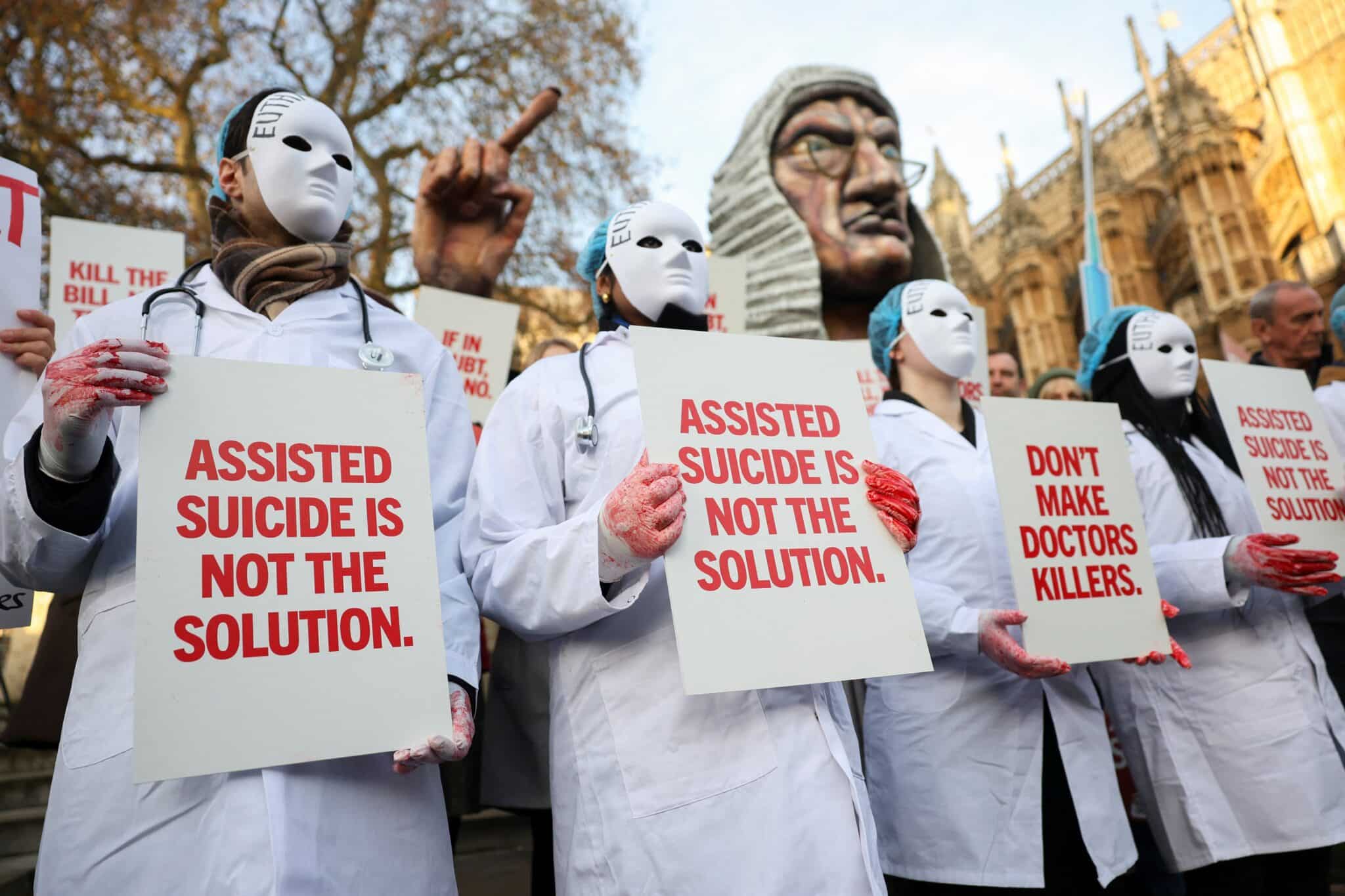 Protestors holds a placard outside Parliament as British lawmakers debate the assisted dying law in London Nov. 29, 2024. Britain's lawmakers voted Nov. 29 to legalize assisted suicide for the terminally ill in England and Wales, despite opposition from Britain's Catholic bishops and other faith groups. (OSV News photo/Mina Kim, Reuters)