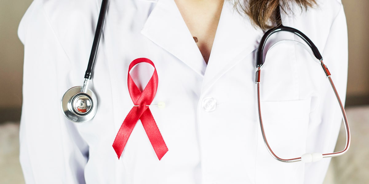 female doctor wearing a red ribbon on her white coat