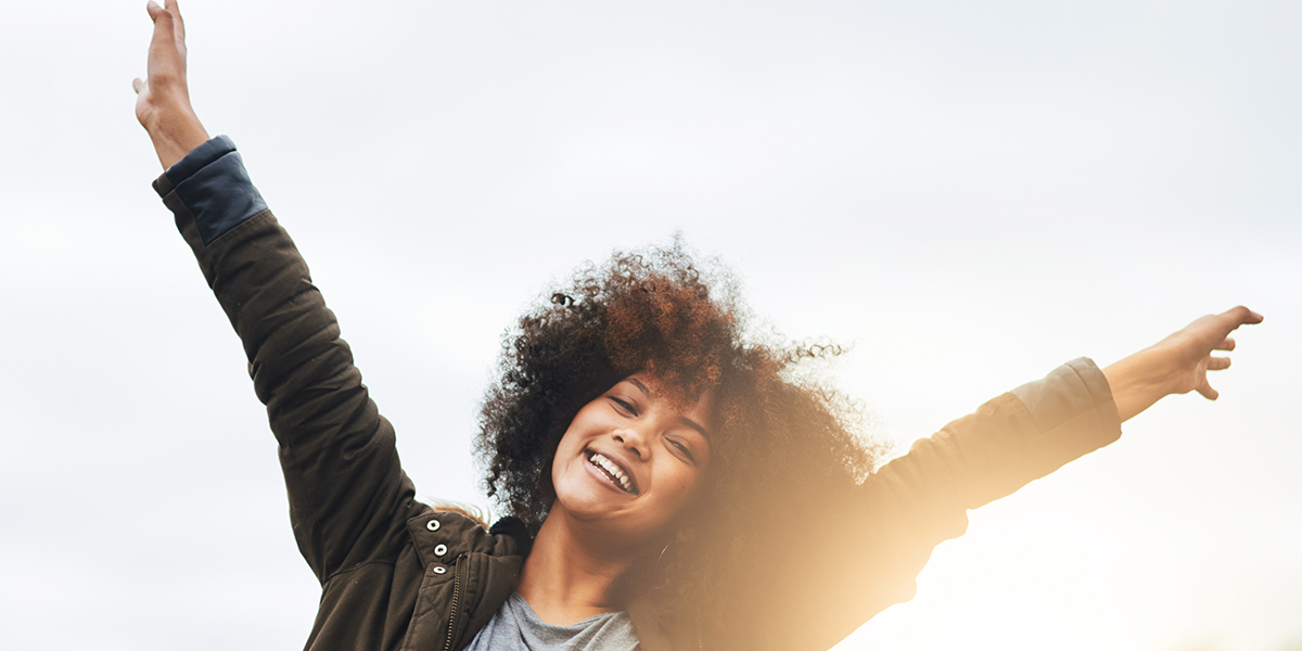 woman joyful, raising her arms