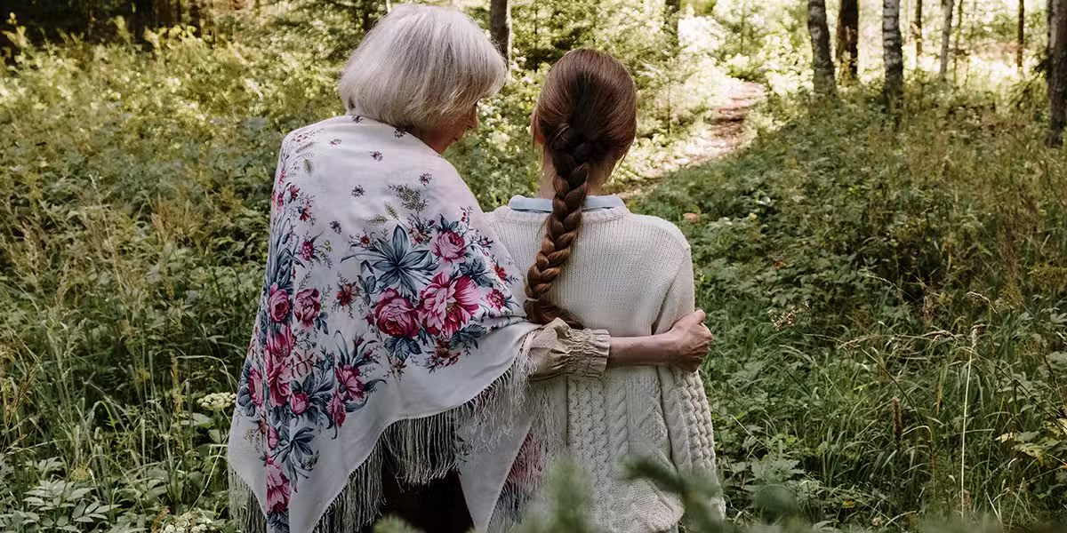 grandmother walking with granddaughter through a field