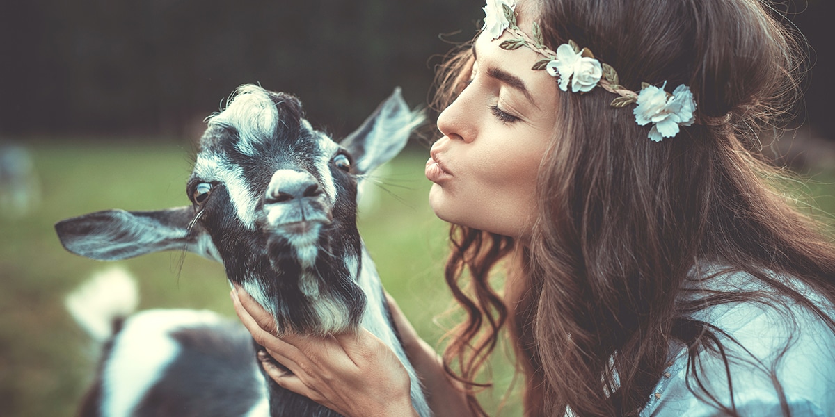 woman making friends with a goat