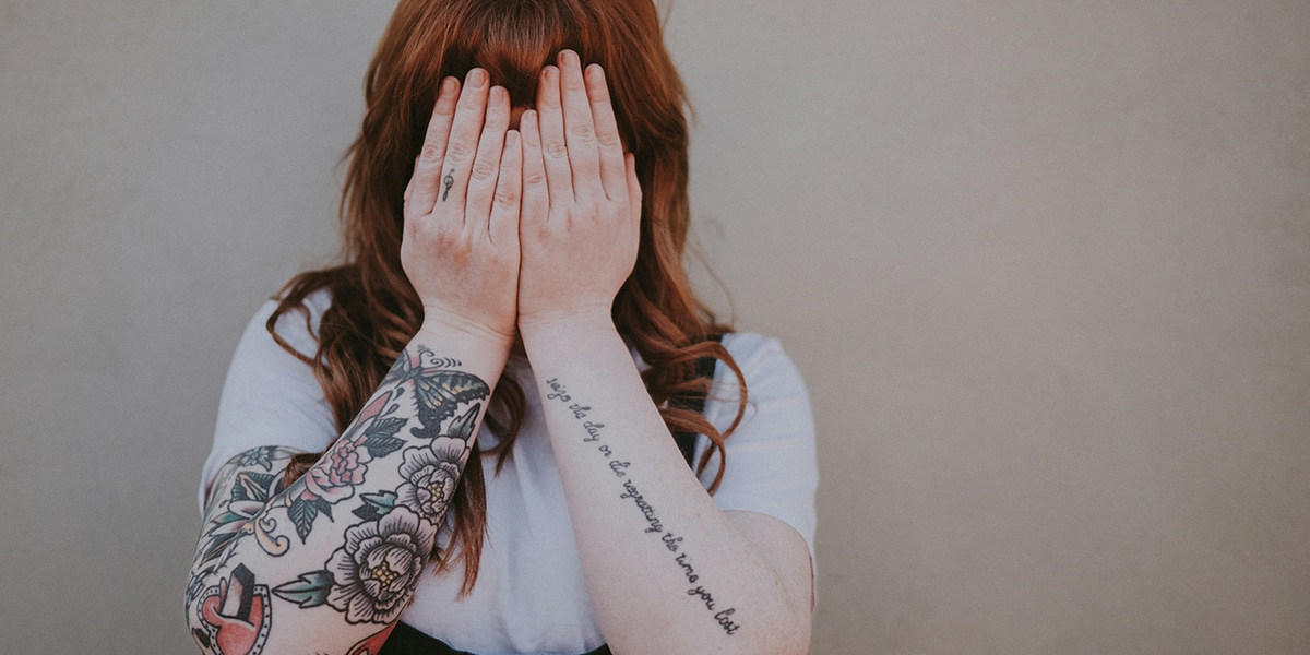 woman covering her face with her hands