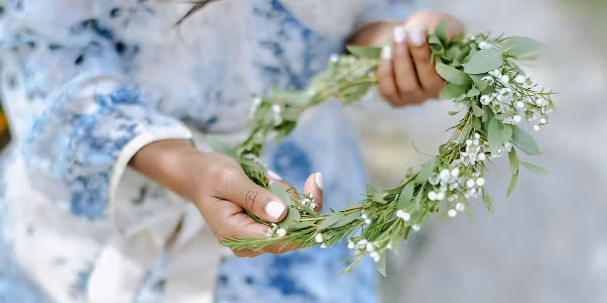 hands holding a flower wreath, crown