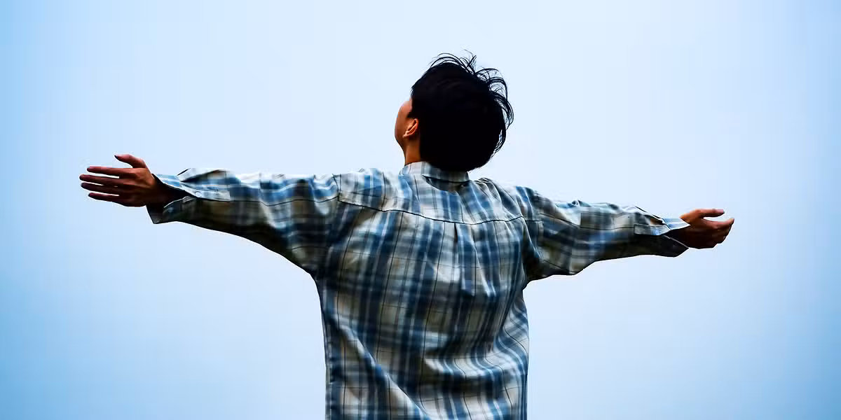 man lifting his arms and head and talking to the sky