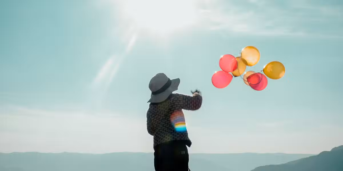 woman releasing balloons into the sky